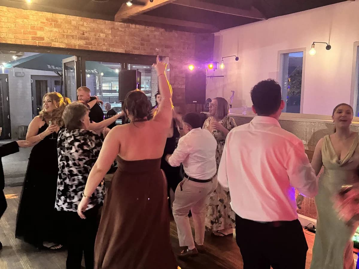 Guests dancing at an Adelaide function with warm lighting