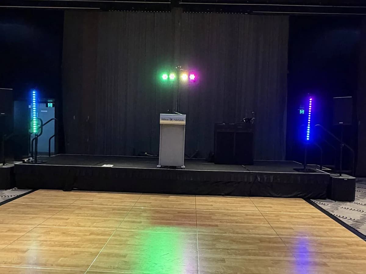 Stage and dance floor lit with colour uplighting at an Adelaide venue